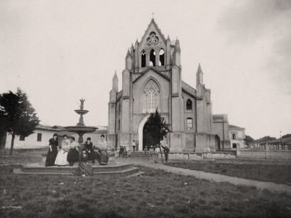 Plaza menor de la iglesia San Nicolás Tolentino, con fuente de los Delfines. Al fondo, detrás de la fuente, se ve una parte del frontón del colegio. Foto de Henry G. Morgan, año 1892