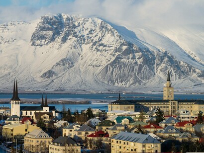 Telhados coloridos contrastam com os picos nevados ao redor de Reykjavik, Islândia. A capital combina charme urbano e proximidade com algumas das paisagens mais impressionantes do país