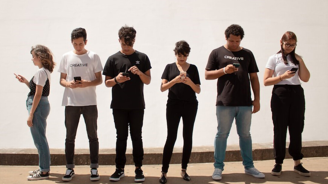 A gathering of individuals engrossed in their mobile phones