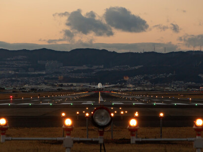 Aereo che decolla e lascia l'aeroporto con un tramonto chiaro sullo sfondo