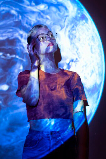A portrait of a young woman with a projection of the universe, radiating spiritual energy, an energy field, and positive chakra energy