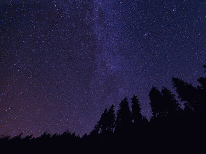 Beneath a stunning purple night sky, the stars remind us that even in the depths of suffering, beauty and hope can shine through