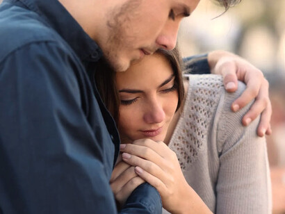 Hombre abraza a una mujer deprimida