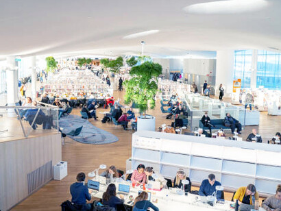 Students collaborate in the innovative spaces of Helsinki’s Oodi Library, utilizing cutting-edge facilities for learning and creativity