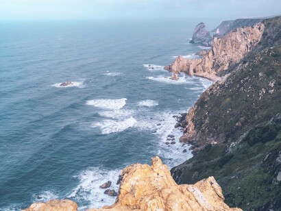 The motioning sea clattering against the rocks