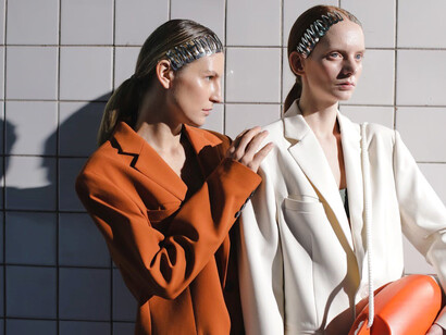 Models showcase oversized blazers and tailored suits, striking a bold statement while holding a lifebuoy, embodying the trend of oversized silhouettes with a touch of nautical flair