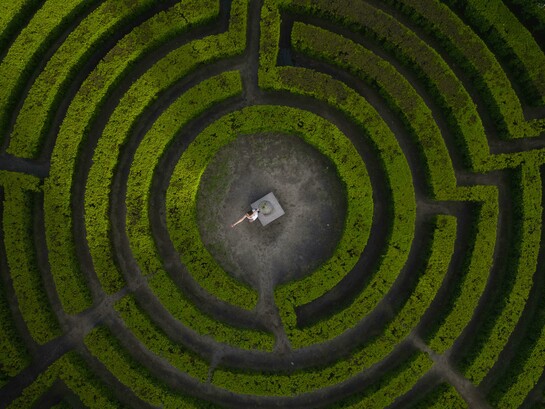 Porto, Portugal, a woman stands in the center of a labyrinth, framed by twisting paths and quiet symbolism
