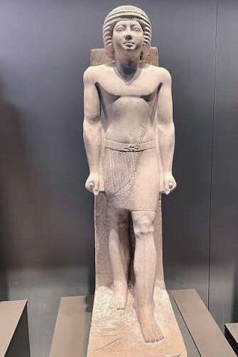 Standing limestone statue of the Old Kingdom official Metjetji, depicted wearing a short pleated kilt and wig, on display at the Egyptian Museum in Cairo, Egypt