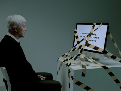 A man stares sadly at a computer displaying a job rejection