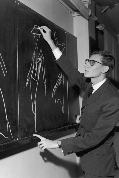 Yves Saint Laurent mentre disegna alcuni modelli