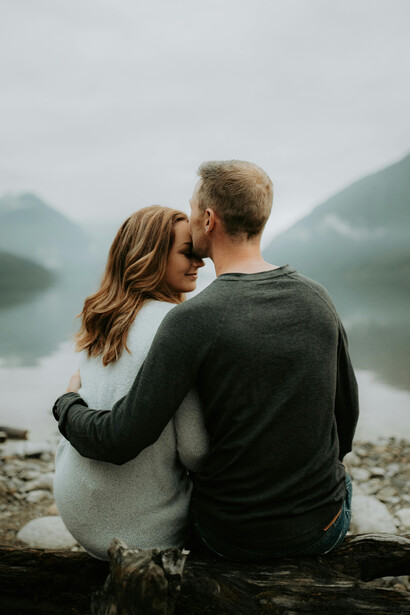 A couple sitting by a river in a mountain valley
