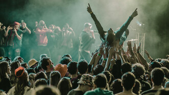 Pessoas de idades diferentes curtem show em festival de música que mescla diferentes gêneros e artistas em um só palco
