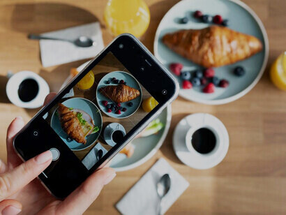 Captured by a food influencer's hands, smartphone photos of a meal showcase the profound impact of social media on culinary trends