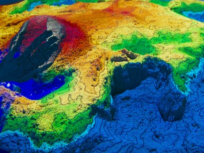 Desenvolvedores da Wikimedia no Ars Electronica Center em Linz, Áustria, brincando com um mapa topográfico em caixa de areia de realidade aumentada. A RA combina o mundo físico com elementos digitais, como imagens, animações e sons, criando experiências imersivas que capturam a atenção e estimulam a curiosidade