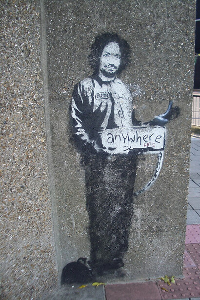 A stencil of Charles Manson in a prison suit, hitchhiking to anywhere, Archway, London, UK