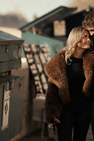 Young couple enjoying a romantic walk beside a dumpster in a gritty urban alley