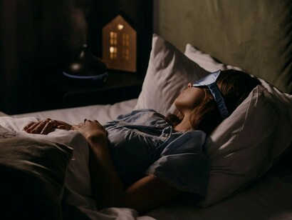 A woman sleeping deeply, wearing a blue sleep band, captured in dreamlike art that explores the connection between sleep and creativity