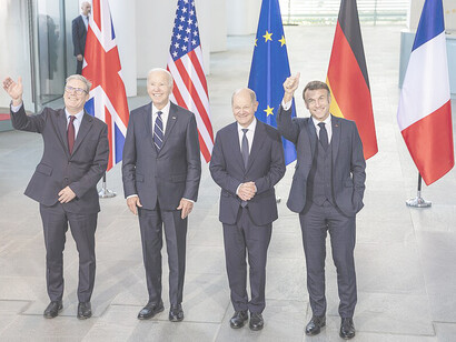 At the Chancellery in Berlin on October 18, 2024, U.K. Prime Minister Keir Starmer chats with Former President Joe Biden as they join German Chancellor Olaf Scholz and French President Emmanuel Macron for a family photo during the “European Quad” leaders meeting