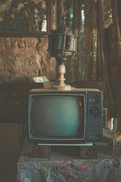 A nostalgic living room scene with a vintage television and soft sunlight streaming through the curtains