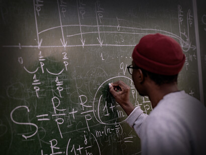 Hombre resuelve una fórmula matemática en una pizarra