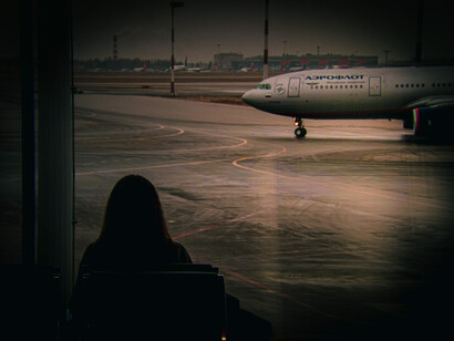 Mujer viendo la pista de aterrizaje de un aeropuerto