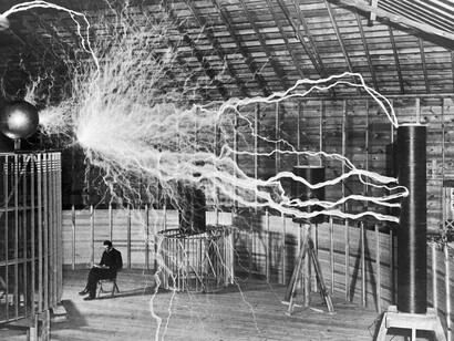 Nikola Tesla en una prueba de su bobina, un tipo de transformador eléctrico resonante