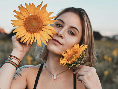 A woman holding vibrant flowers to her face
