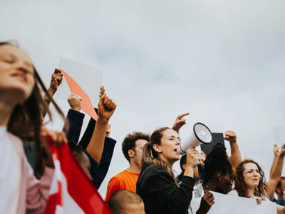 A group of protesters holding signs, advocating for activism, human rights, and justice in the pursuit of change