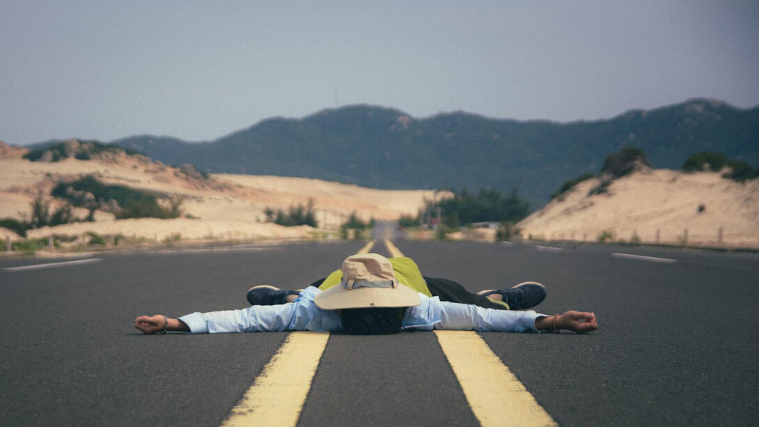 Homem deitado e respirando fundo sobre o asfalto: quando o estresse fala mais alto