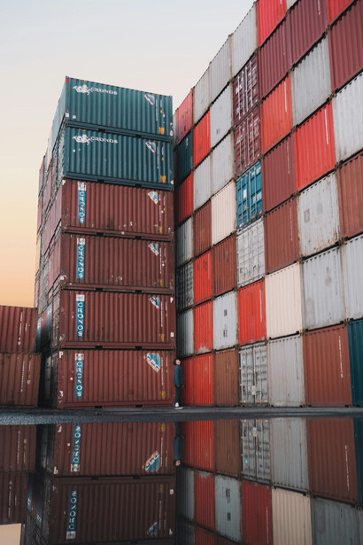 Shipping containers neatly stacked at a busy freight yard