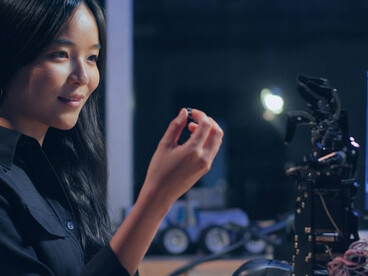 A woman operates a robotic hand in a high-tech laboratory