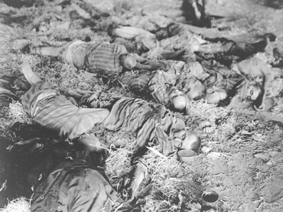 Trabajadores muertos yacen en filas desiguales en los pisos de los cuarteles del campo de concentración de Nordhausen, 1945