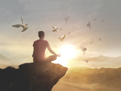 Mujer meditando en una montaña