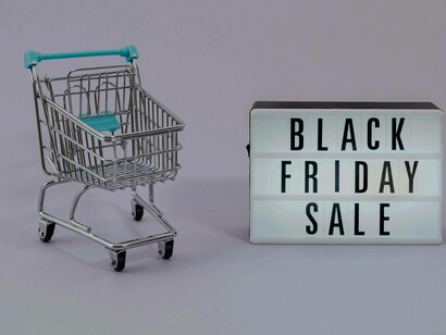 A shopping cart and black friday sign represent e-commerce