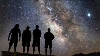 Beneath a blanket of stars, a group gazes skyward, finding solace in the vastness of the cosmos, where individual plans fade into the brilliance of universal mysteries