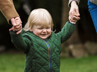 Parents walking with their cute child in the park, showcasing individuality, self-expression, and childhood independence