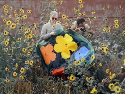 Andy Warhol in a Field of Black-Eyed Susans Holding an Early “Flowers” Canvas with Taylor Mead in New York (detail). Image copyright William John Kennedy. Courtesy of Woodbury House 