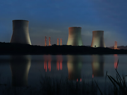 A nuclear power plant at night, highlighting the process of fuel and power generation through nuclear reactor energy