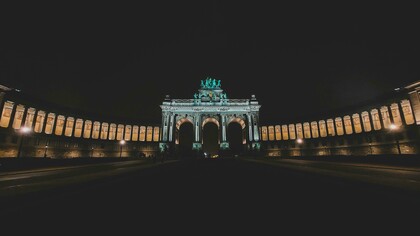 In Brussels, Belgium, the night unfolds under a deep, dark sky, framing a magnificent arch glowing in the distance