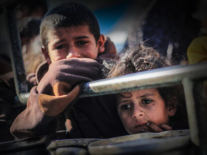 Niños palestinos miran al horizonte mientras huyen del conflicto armado en la Franja de Gaza