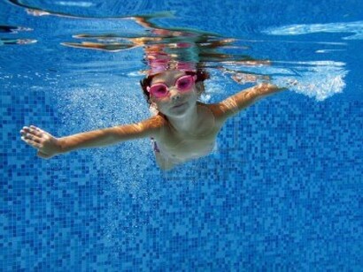 Una niña bucea en una piscina