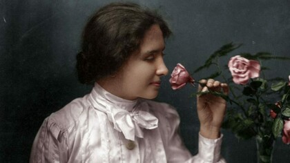 Helen Keller sniffing a pink rose and capturing the essence of the smell