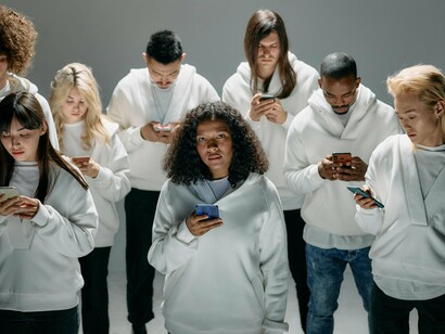 People standing motionless while scrolling, symbolising the addictive pull of endless digital stimulation