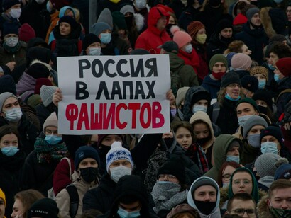 Um grande grupo de pessoas usando máscaras faciais protestanto contra a prisão ilegal do líder da oposição russa Alexey Navalny