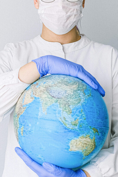 Doctora mostrando un globo terráqueo. El cambio climático influye en la propagación y el surgimiento de enfermedades infecciosas