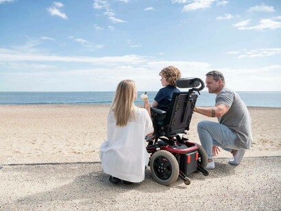 Parents take their special needs child to the beach on vacation