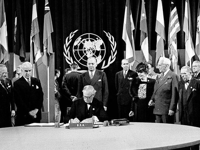 President Harry S. Truman and the entire American delegation look on as Sen. Tom Connally signs the United Nations Charter in San Francisco, June 26, 1945. Standing, from left: President Truman; Secretary of State Edward Stettinius Jr.; Harold Edward Stassen; unidentified; Dean Virginia Gildersleeve; Rep. Charles A. Eaton; Rep. Sol Bloom, and Sen. Arthur Vandenberg (AP Photo)