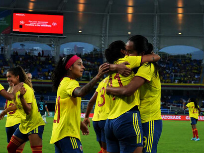 Jugadoras de la Selección Colombia de fútbol se abrazan después de marcar un gol