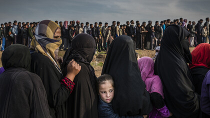Abitanti di Mosul fanno la fila per ricevere cibo mentre sono in corso gli scontri per liberare la città dai miliziani del gruppo Stato islamico, 15 marzo 2017. The Battle for Mosul - Lined Up for an Aid Distribution © Ivor Prickett, for The New York Times 