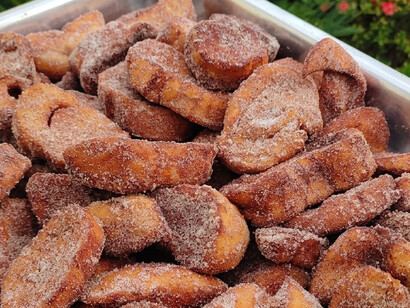 Um recipiente repleto de rabanadas douradas desperta lembranças das tradicionais celebrações natalinas. No texto, elas são o sabor que torna inesquecíveis as visitas ao casal de vizinhos